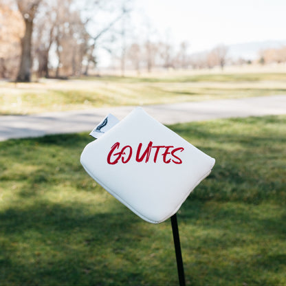 White sign with 'GO UTES' on a grassy area with trees in the background
